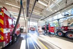 Seattle Fire Station 32 interior bay between two trucks.