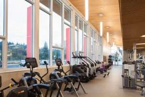 Eastside Community Center in Tacoma, interior view of exercise machines at window with CLT roof overhead.
