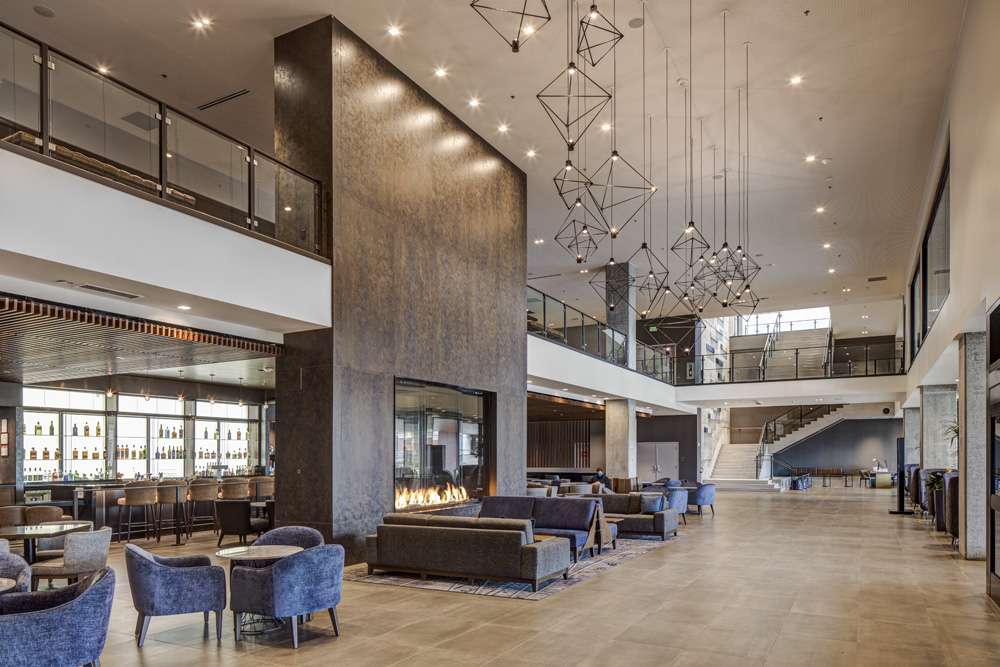 Tacoma Convention Center Hotel Tacoma Convention Center Hotel first-floor lobby with fireplace, seating, and bar.