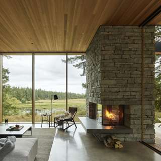 Whidbey Island Farmhouse living room with stone fireplace and meadow view