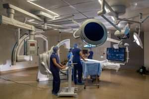 Harborview Medical Center Bi-Plane Operating Room with doctor and technicians and featuring 15,000 pounds of imaging equipment