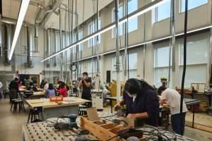 Highline High School students working in shop classroom with high open ceilings and windows, Burien, WA