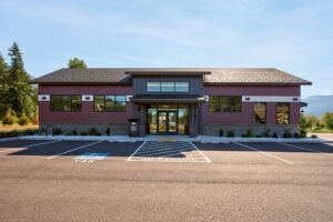 The entrance of a red and black library building with large windows.