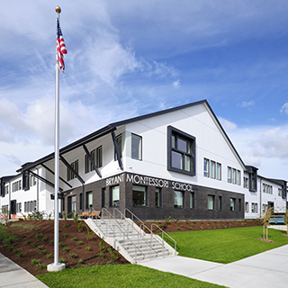 A white and brown school building has large lettering on its side that reads "Bryant Montessori School."