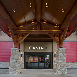 Round wood logs form the structure of a covered wooden entryway to the casino.