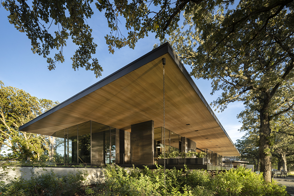 Highbank-Residence-Gallery A broad wood roof cantilevers over glass and concrete walls.