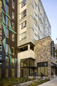 The street-level entrance to a large apartment building with many windows.