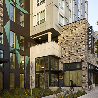 The street-level entrance to a large apartment building with many windows.