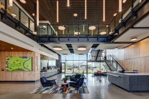 An expansive, wood-walled and wood-ceilinged public lobby with brightly lit windows in the background.